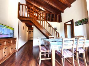 a dining room with a table and chairs and a staircase at AC Apartaments Solana Ransol in Ransol