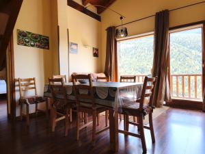 a dining room with a table and chairs and a balcony at AC Apartaments Solana Ransol in Ransol