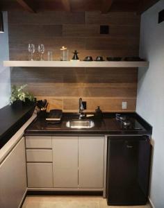 a small kitchen with a sink and a counter at Hop Village in Praia do Rosa