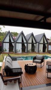 a deck with chairs and a table and a pool at Hop Village in Praia do Rosa