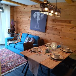 a dining room with a table and a blue couch at Pearly Maison Central Ruffec in Ruffec