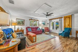 a living room with a couch and chairs at Buttonwood Cottage in Anna Maria