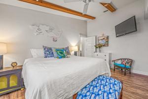 a bedroom with a bed and a tv on the wall at Buttonwood Cottage in Anna Maria