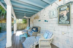 a porch with wicker chairs and a sign on a wall at Buttonwood Cottage in Anna Maria +38 photos