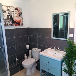 a bathroom with a toilet and a sink and a mirror at Pearly Maison Central Ruffec in Ruffec +10 photos