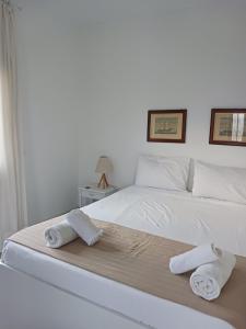 a bedroom with a white bed with towels on it at Ακροδεα in Áno Gávrion