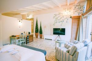 a room with a bed and a desk and a tv at Hotel Finca Ca N'ai - Adults Only in Sóller