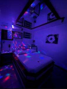 a bedroom with a bed with purple lights on it at Lemonte Motel in Brusque