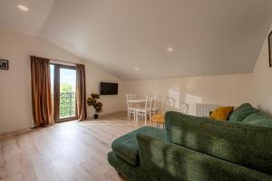 a living room with a green couch and a table at Sella Mestia in Mestia