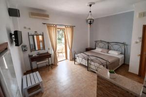 a bedroom with a bed and a table and a mirror at NEFELI by Evita's Resort in Poros