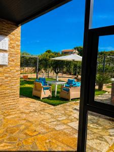 a patio with a table and chairs and an umbrella at Belvedere Hotel & Suites in Himare