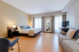 a hotel room with a bed and a couch at TURIM Aveiro Palace Hotel in Aveiro