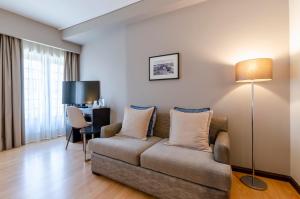 a living room with a couch and a desk at TURIM Aveiro Palace Hotel in Aveiro
