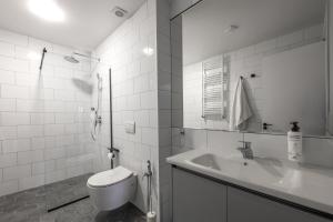 a white bathroom with a toilet and a sink at Sella Mestia in Mestia +48 photos