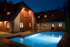 a swimming pool in front of a house at night at Cztery Pokoje in Kazimierz Dolny