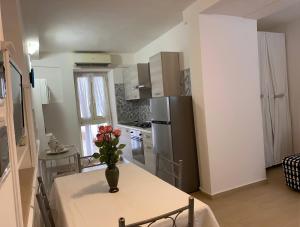 a kitchen with a table with a vase of flowers on it at Villa Paradiso in Gaeta