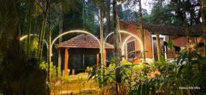a small house in a forest with lights on it at Twin Retreat in Madikeri