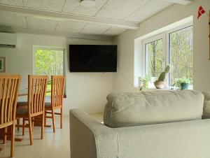 a living room with a couch and a table with chairs at Sønderhedens B&B in Vrå
