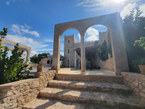 a building with a stone wall and some stairs at Dar Ez-zine in Ounara
