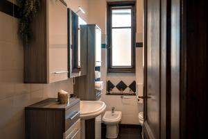 a bathroom with a sink and a toilet and a window at Chromatica - di fronte a Galleria Bomb in Gorizia