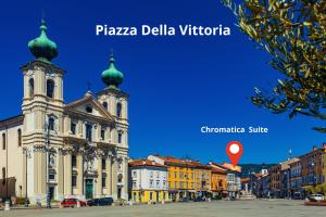 a building with a clock tower in a city at Chromatica - di fronte a Galleria Bomb in Gorizia