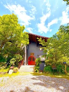 a house with a red door and some trees at IZUNA INN & SPA - the veggie delights in Ito +58 photos