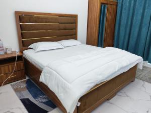 a bedroom with a large bed with a wooden headboard at Elegant Sea View Apartment in Ajman  +10 photos