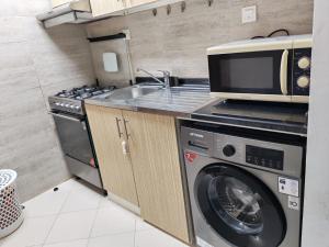 a kitchen with a microwave and a washing machine at Elegant Sea View Apartment in Ajman 
