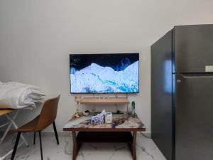 a desk with two chairs and a refrigerator in a room at Elegant Sea View Apartment in Ajman 
