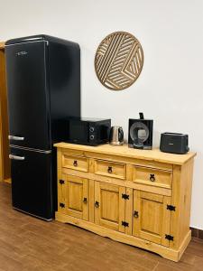 a black refrigerator sitting next to a wooden dresser at Ubytování pod Borovou in Malenovice