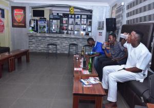 a group of men sitting on a couch in a bar at P Meridian Hotels in Awoyaya