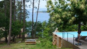 a house with a pool and a view of the water at Amaraxe Ecoglamping in Miñortos
