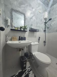 a white bathroom with a toilet and a sink at Bali-Inspired Pool Haus Cebu in Lapu Lapu City