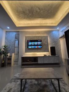 a living room with a table and a tv on a wall at Bali-Inspired Pool Haus Cebu in Lapu Lapu City