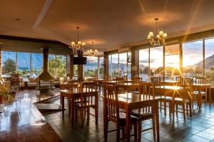ein Restaurant mit Holztischen und -stühlen und Fenstern in der Unterkunft Hotel Sol del Sur in Esquel