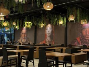 a dining room with tables and portraits on the walls at Atlas Safari in Meknès