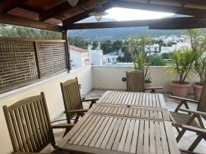 a wooden table and chairs on a balcony at K-Loft Urban Athens in Pallini