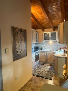 a kitchen with white cabinets and a picture on the wall at K-Loft Urban Athens in Pallini +8 photos