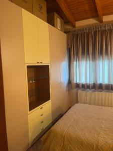a bedroom with a bed and a dresser with a television at K-Loft Urban Athens in Pallini