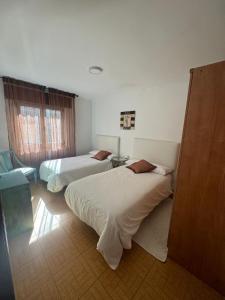 a hotel room with two beds and a couch at Casa de la bis in A Guarda