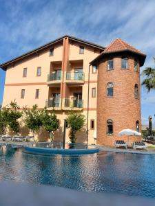 a building with a swimming pool in front of a building at Rambuje Resort in Lezhë