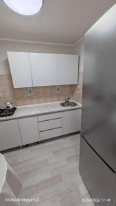 a kitchen with white cabinets and a sink at Aktau 4-31 in Aktau