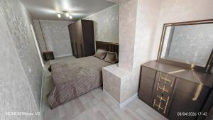 a small bedroom with a bed and a dresser at Aktau 4-31 in Aktau