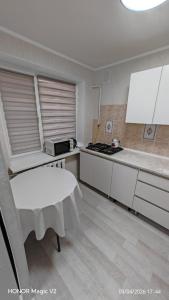 a kitchen with a white table in a room at Aktau 4-31 in Aktau