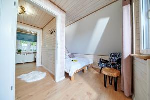 a bedroom with a bed and a chair in a room at Domki nad Zaporą w centrum Soliny przy Zaporze - wybrane domki z jacuzzi in Solina +286 photos