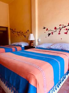 two beds in a room with birds on the wall at Casa Colibri La Punta in Brisas de Zicatela