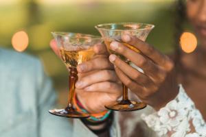 a man holding two wine glasses in his hands at Gatherwild Ranch in Germantown