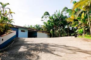 a building with a parking lot with palm trees at Lemonte Motel in Brusque