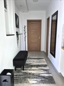 a hallway with a black ottoman in front of a door at STD AFRODITA Apartment & Garden in Vrdnik +31 photos