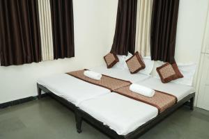 two beds in a room with two pillows on them at Hotel laxminarayan niwas in Shirdi